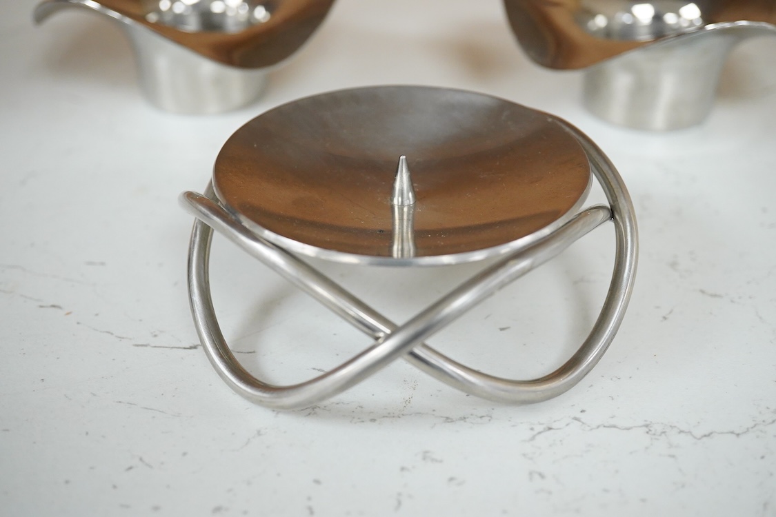 A pair of Georg Jensen stainless steel Cobra candleholders and a Georg Jensen Glow candle, latter 10cm diameter.